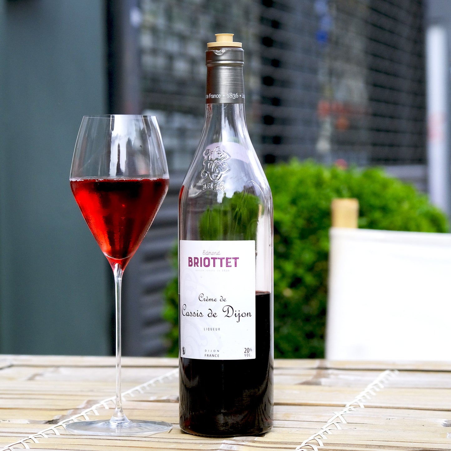 Briottet Blackcurrant Liqueur in a big glass on a table outside