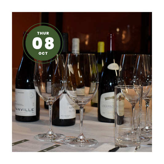 Burgundy bottles on wine tablecloth with thin-stemmed wine glasses