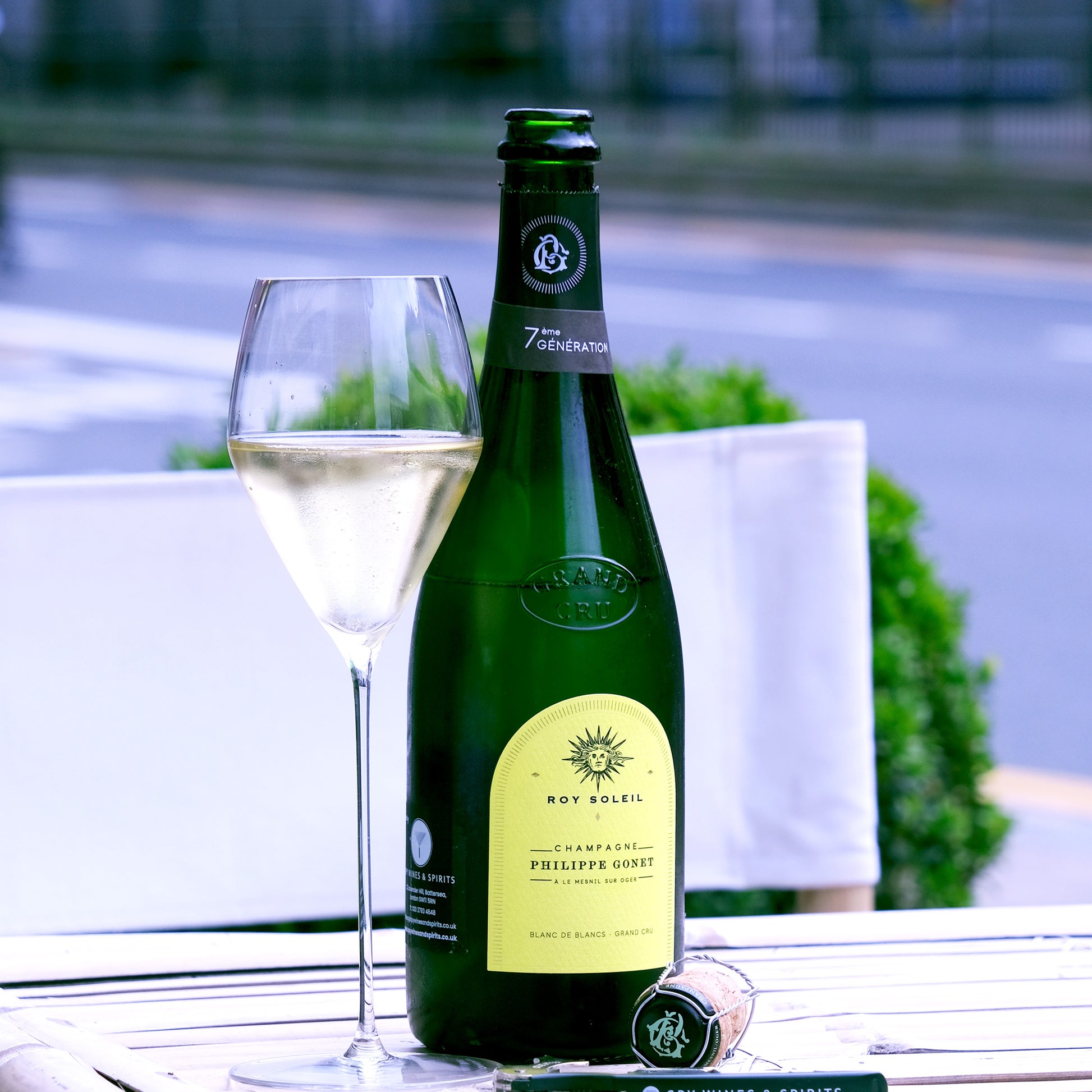 Roy Soleil Grand Cru Champagne bottle and in specialist sparkling glass on a table in sunshine