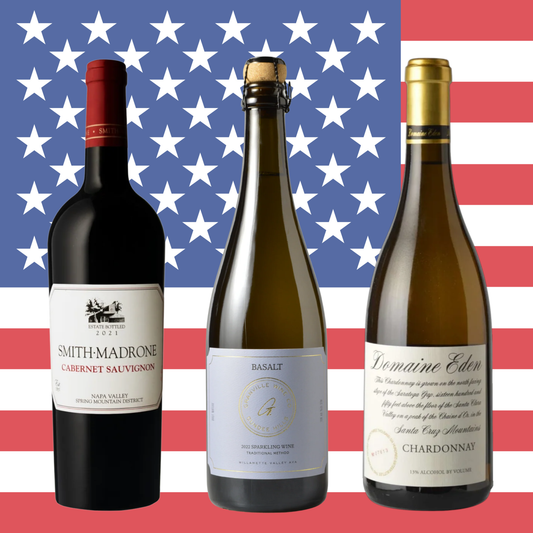 Three wine bottles arranged side by side against an American flag background. The left bottle is a dark red wine by Smith-Madrone, the center bottle is a sparkling by Granville, and the right bottle is a oaked, creamy Chardonnay by Domaine Eden.